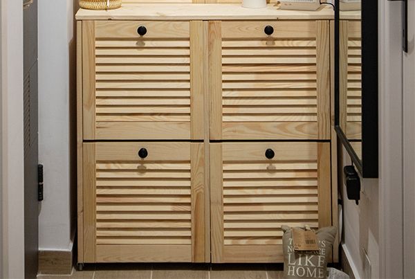 Vizigon renovation detail: natural pine louvred shoe cabinet in the hallway of a 27 sqm apartment